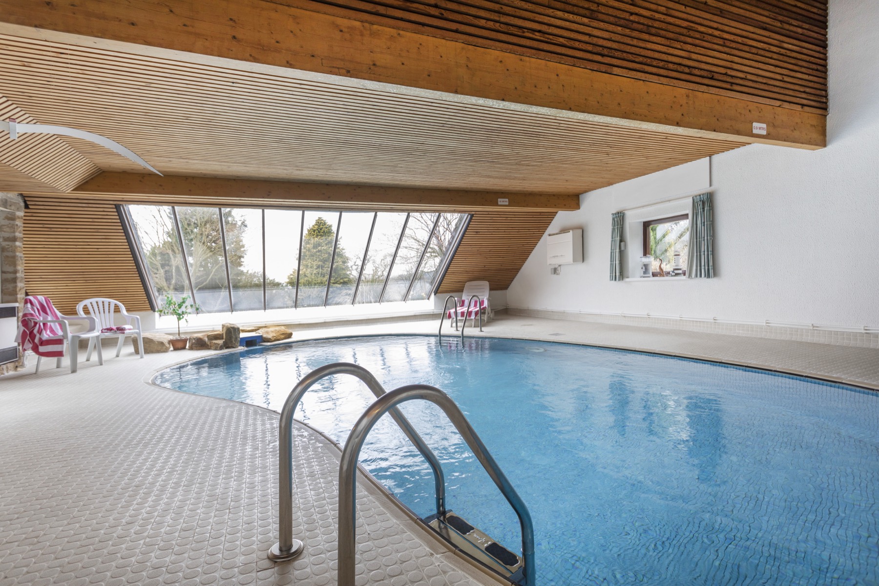The heated indoor pool with its glass wall onto the garden
