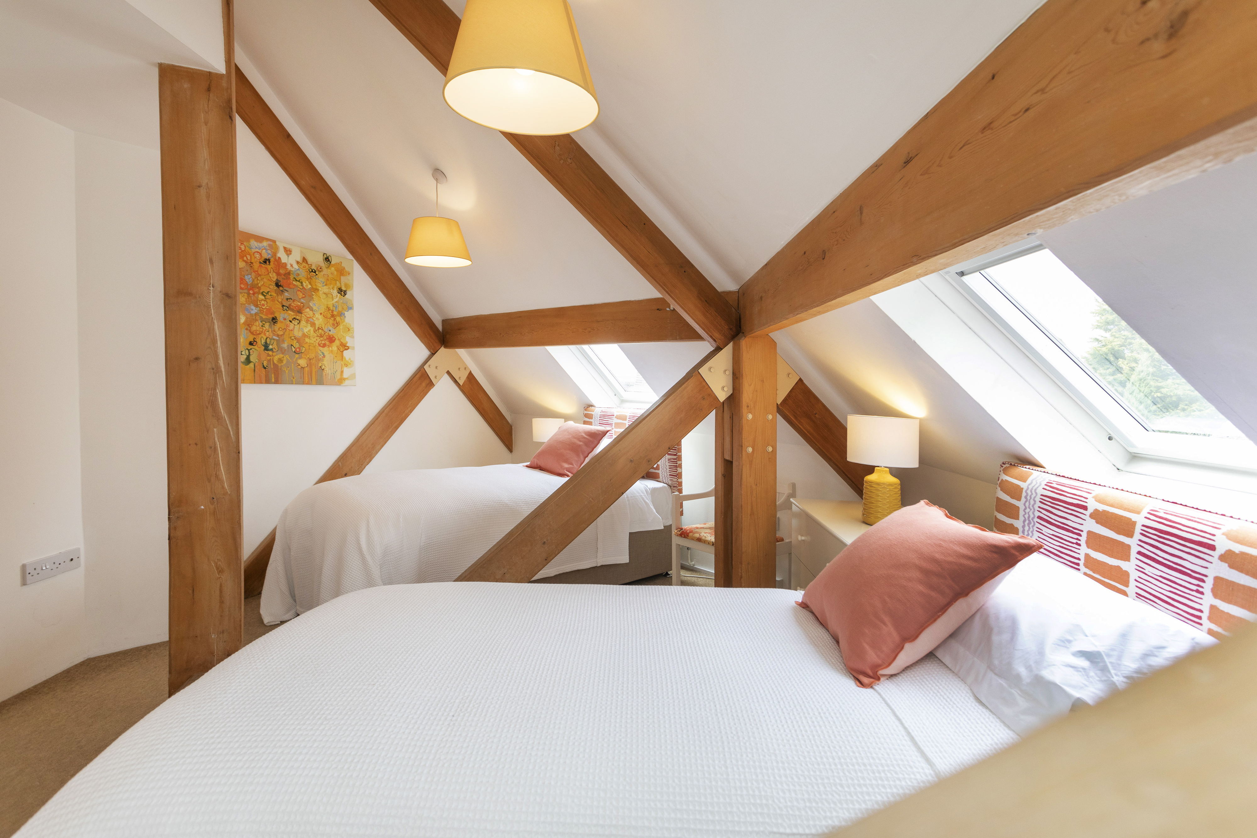 The twin bedroom upstairs at The Round House, under the beams