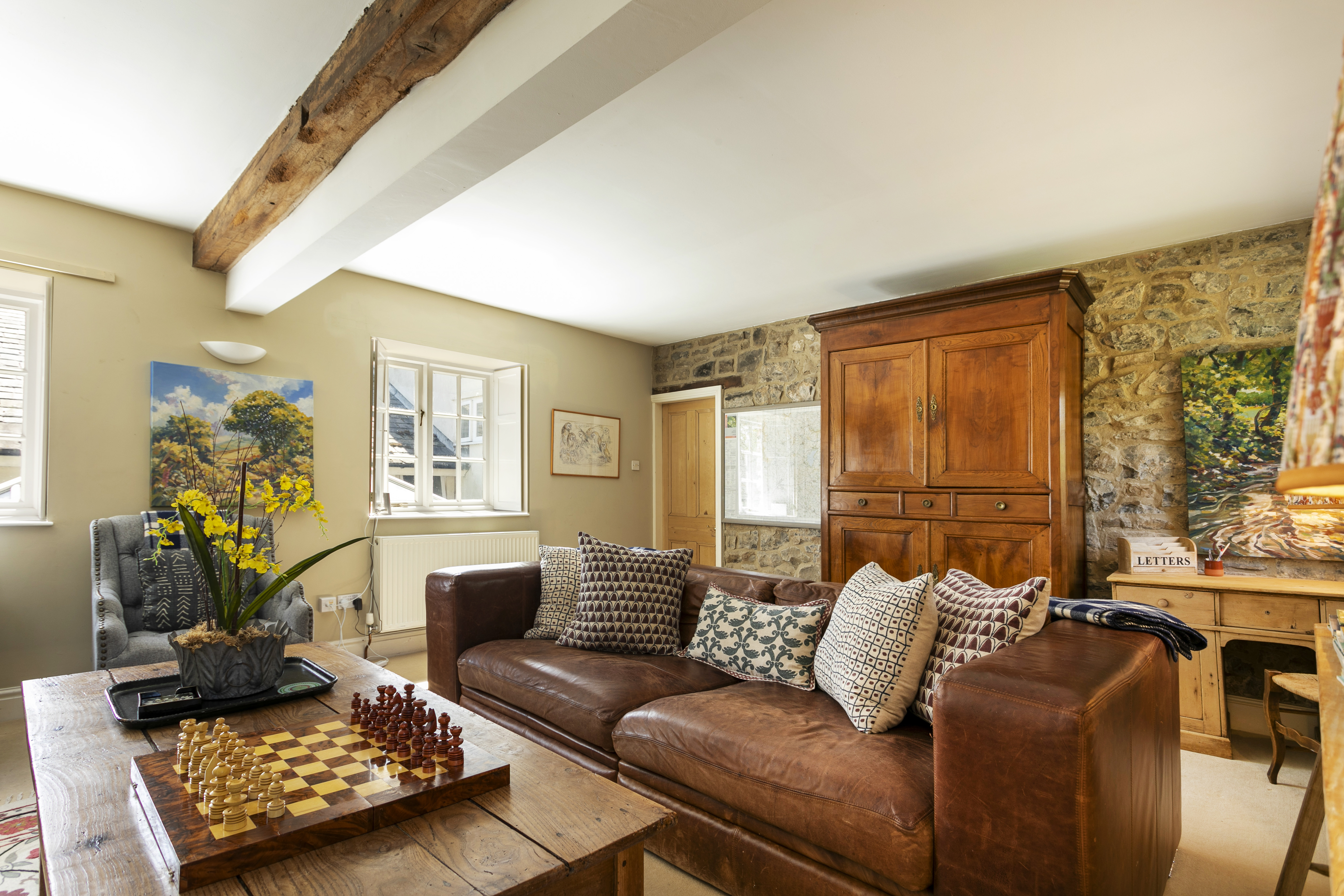 The sitting room at Swallow's Cottage, antiques and the woodburning stove, ready for winter